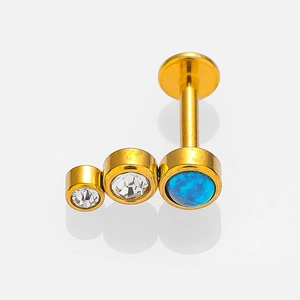 Golden stainless steel labret stud with blue opal and white zircon stones on white background