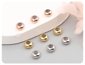 Detailed view of polished 14K gold-filled silicone slider beads in gold, silver, and rose gold