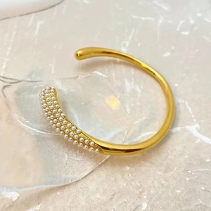 Bracelet jonch ouvert plaqué or 18 carats avec perles et zircone sur marbre