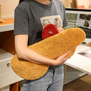 Close-up of textured peanut plush pillow held by a person in a cozy office setting