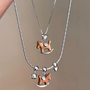 Collier cheval à bascule Saturne en bois et zircon avec finition argentée élégante