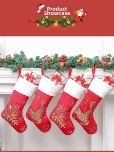 Detail of red velvet Christmas stockings with golden reindeer and snowflake embroidery