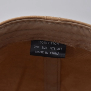 Detail view of the cotton interior with size and material labels on this plaid flat cap