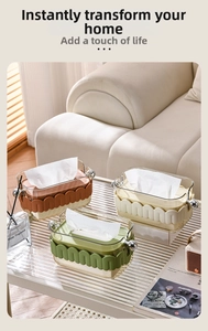 Detail of luxury tissue box with wave pattern base and metal ball handles in warm home setting