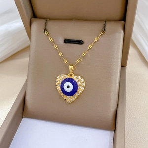 Close-up of heart-shaped evil eye pendant with sparkling zircons on gold chain