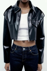 Close-up of black faux leather jacket detail featuring metallic zipper and shoulder epaulettes