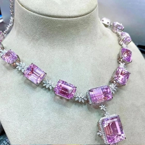 Detailed close-up of luxury emerald-cut pink gemstone necklace with diamond flower links