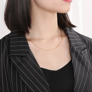 Classic gold stainless steel lip chain necklace displayed on a female model wearing a suit