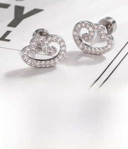 Close-up of heart-shaped wing cartilage earrings with sparkling cubic zirconia inlay
