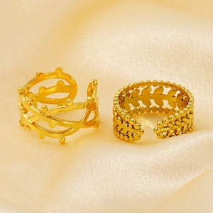 Detail of two 18k gold plated adjustable rings with vine and leaf patterns on satin
