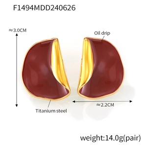 Macro detail of French style burgundy enamel earrings with golden titanium steel edges