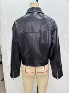 Détails des coutures arrière et de la texture en similicuir de la veste de motard noire