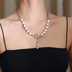 Detail of silver hollow star pendant with diamonds on a bead and pearl necklace