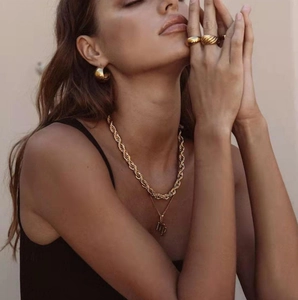 Golden chunky twisted rope chain necklace and layered jewelry set on a model