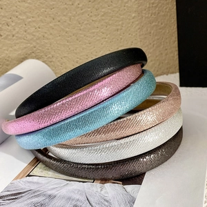 Close-up of glitter fabric padded headbands in six vibrant candy colors stacked together