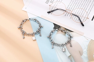 Detail of double-layer titanium steel bracelet with ball chain and padlock key charms