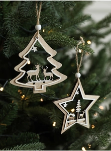 Detail of wooden star and tree Christmas ornaments hanging on a green tree with bokeh lights