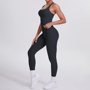 Detail of black high-waisted yoga leggings with side pockets and slim-fit sports tank top