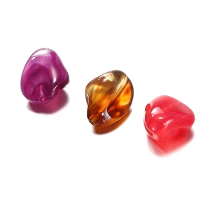 Close-up of irregular acrylic stone beads in purple and amber with marble textures