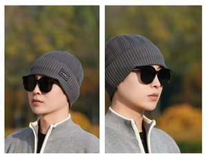 Close-up of grey ribbed knit beanie with FARDI logo patch and warm ear protection