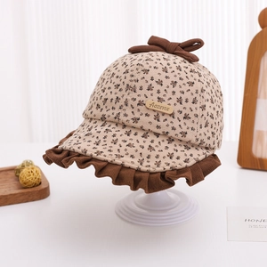 Close-up of baby girl floral sun hat with brown bow and elegant leather logo tag