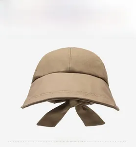 Detail of khaki wide brim sun hat featuring elegant rear bow tie and premium cotton texture
