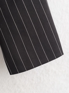 Close-up of classic black pinstripe suit fabric showing twill texture and white stripes