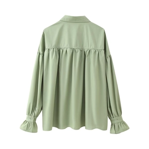 Detail view of sage green long sleeve blouse featuring back pleated design and ruffled cuffs