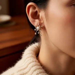 Boucles d'oreilles fleur dorées avec perle et zircons portées par un mannequin femme