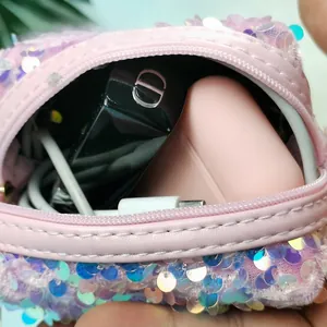Detailopname van roze lovertjes mini-tasje voor oortelefoons en lippenstift met rits
