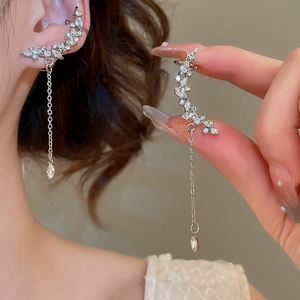 Macro detail of silver tassel earrings with marquise zircon stones and dangling fine chains