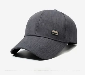 Detail view of dark grey baseball cap showing peak logo badge and twill texture stitching