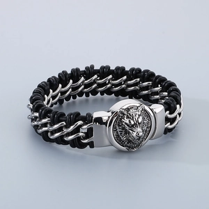 Close-up of wolf head magnet clasp on black braided leather and steel chain bracelet