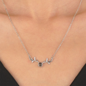 Silver deer antler pendant necklace with crystal accents and projection stone on neck