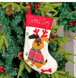 Dettaglio calza di Natale rossa con ricamo Good Dog e motivo cane su albero decorato