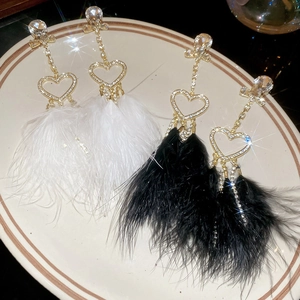 Elegant feather tassel earrings with heart-shaped diamonds and large sparkling gems