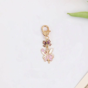Detail of pink and purple fairy pendant with golden heart lobster clasp and bow