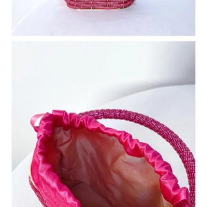 Detail view of the spacious satin interior and beaded bottom of this rose pink bucket bag