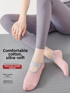Close-up of pink yoga socks with grey cross straps and white non-slip silicone dots