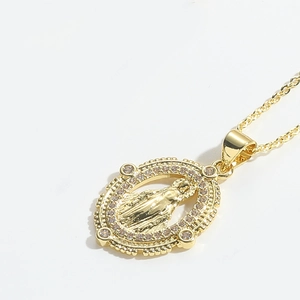 Detail shot of a golden oval pendant featuring Virgin Mary relief and small rhinestones