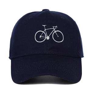 Detailed view of white bicycle embroidery on navy blue cotton twill baseball cap