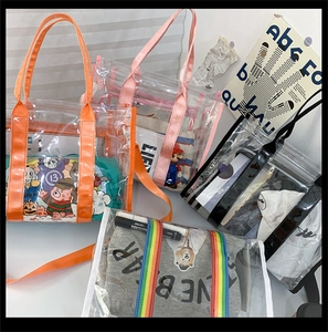 Macro view of transparent PVC tote bags with colorful orange, pink and rainbow straps