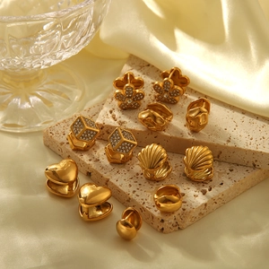 Collection détaillée de boucles d'oreilles dorées sur travertin avec des reflets soie