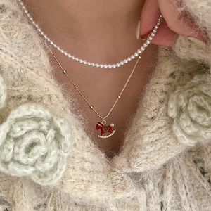18K gold plated pearl necklace set with a red enamel rocking horse pendant on gold chain