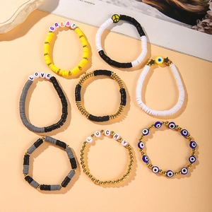 Close-up of polymer clay bracelets featuring Great, Love, Lucky letter beads and evil eye charms