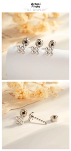 Detailed view of three pairs of silver clover-shaped stud earrings with screw backs