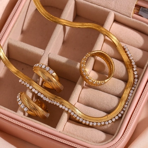 Macro detail of 18K gold plated jewelry set with zircon fishbone texture pattern
