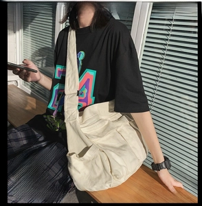 Detail of canvas crossbody bag with dual front pockets and shadow light effects