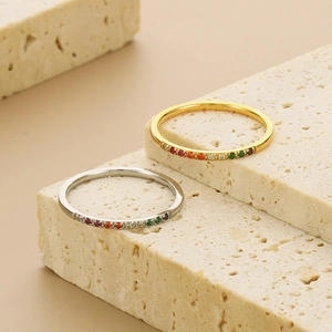 Detail of gold and silver titanium steel rings with multi-color zircon stones