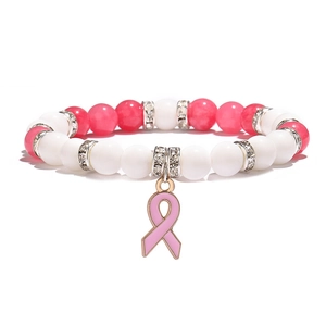 Détail d'un bracelet en perles avec ruban rose, perles blanches et séparateurs en cristal